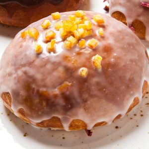 Pączek pieczony z konfiturą z płatków róży z lukrem i skórką pomarańczową